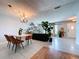 Open concept living and dining room with tile floors, light gray walls and many houseplants at 212 Overlook Dr, Winter Haven, FL 33884