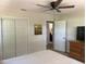 This bedroom features an overhead fan, a painting, and a closet with white folding doors at 2748 Cr 543, Sumterville, FL 33585