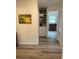 Hallway with wood-look floors, linen closet, decorative painting, and entryways to other rooms at 2748 Cr 543, Sumterville, FL 33585