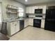Bright kitchen with white cabinetry, stainless steel appliances, granite countertops, and open shelving at 2748 Cr 543, Sumterville, FL 33585