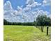 Expansive grassy land surrounded by trees and a wood and wire fence at 2748 Cr 543, Sumterville, FL 33585