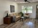 Bright living room with wood-look flooring, cozy seating, and large windows that provide ample natural light at 2748 Cr 543, Sumterville, FL 33585