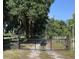 Gated property entrance with mature trees and lush greenery along the drive at 2748 Cr 543, Sumterville, FL 33585