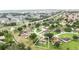An aerial view of a neighborhood, featuring homes surrounded by trees and green spaces near roadways at 413 Bay Leaf Dr, Poinciana, FL 34759