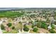 Aerial view of a residential community near a lake, surrounded by trees at 413 Bay Leaf Dr, Poinciana, FL 34759