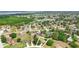 Aerial view of a home within a community near a lake, surrounded by trees at 413 Bay Leaf Dr, Poinciana, FL 34759