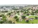 An aerial view of a neighborhood, featuring homes surrounded by trees and green spaces near roadways at 413 Bay Leaf Dr, Poinciana, FL 34759