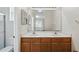 Bathroom with double sink vanity, wood cabinets, and large mirror at 413 Bay Leaf Dr, Poinciana, FL 34759