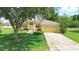 Charming single-story home with a well-manicured lawn and mature trees at 413 Bay Leaf Dr, Poinciana, FL 34759