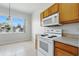 Bright kitchen features tile floors, wooden cabinets, and modern white appliances at 413 Bay Leaf Dr, Poinciana, FL 34759