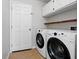 Functional laundry area with washer, dryer, overhead cabinets and tiled floor at 413 Bay Leaf Dr, Poinciana, FL 34759