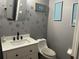 A bathroom with a white vanity, modern black fixtures, and dragonfly-themed wall decor and a framed wall art at 609 Linnet Ct, Poinciana, FL 34759