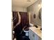 This is a bathroom with a black and gold shower curtain and matching toilet seat cover and rug at 609 Linnet Ct, Poinciana, FL 34759