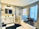 Well-lit bathroom featuring a soaking tub, a glass door shower and a vanity with mirror and stylish lighting at 609 Linnet Ct, Poinciana, FL 34759