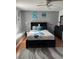 Bedroom featuring a queen size bed, hard wood floors, and cool toned decorations and furniture at 609 Linnet Ct, Poinciana, FL 34759