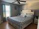 Cozy bedroom with a ceiling fan, hardwood floors, neutral color palette, and a queen-size bed at 609 Linnet Ct, Poinciana, FL 34759