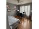Bedroom with wood floors, ceiling fan, white curtains, and a computer desk by the window at 609 Linnet Ct, Poinciana, FL 34759