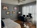 Bedroom with wood floors, ceiling fan, white curtains, and a computer desk by the window at 609 Linnet Ct, Poinciana, FL 34759