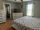 Bedroom with hard wood floors, modern furniture, TV, and plenty of natural light with ensuite bathroom at 609 Linnet Ct, Poinciana, FL 34759