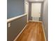 Hallway with wooden floors, light gray and blue walls, and white trim and doors at 609 Linnet Ct, Poinciana, FL 34759