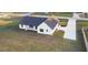 Aerial view of a modern farmhouse with a long driveway and a well-maintained lawn at 112 Cr 532B, Bushnell, FL 33513