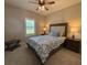 Cozy bedroom with a patterned comforter, warm lighting, and a window with plantation shutters at 112 Cr 532B, Bushnell, FL 33513