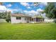 Lush backyard with a well-manicured lawn and view of the home's screened-in porch at 1511 Avenue F Ne, Winter Haven, FL 33881