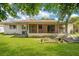 A spacious backyard featuring a well-maintained lawn, garden, and a screened in porch at 1511 Avenue F Ne, Winter Haven, FL 33881