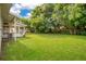 Expansive backyard with well-maintained lawn, mature trees, and rear porch at 1511 Avenue F Ne, Winter Haven, FL 33881