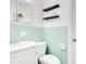 Charming bathroom with vintage mint tile, updated fixtures and modern shelving at 1511 Avenue F Ne, Winter Haven, FL 33881