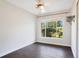 Bright bedroom with wood-look flooring and a large window offering backyard views at 1511 Avenue F Ne, Winter Haven, FL 33881