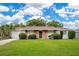 Charming single-story home with a well-maintained lawn, brick accents, and a beautiful green front door at 1511 Avenue F Ne, Winter Haven, FL 33881