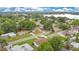 Aerial view showcases residential streets, lawns, mature trees, and a view of a distant lake at 1511 Avenue F Ne, Winter Haven, FL 33881