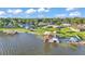 Scenic aerial view of waterfront property with a private dock, boat lift, and picturesque lake surroundings at 390 Windermere Dr, Lakeland, FL 33809