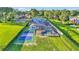 Aerial view of a home with a pool, spa, pickleball court, solar panels, and manicured landscaping at 390 Windermere Dr, Lakeland, FL 33809
