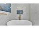 Soaking tub with gold fixtures, marble tile surround and blue tile niche in a luxurious primary bathroom at 390 Windermere Dr, Lakeland, FL 33809