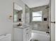 Bathroom featuring a marble vanity, bathtub, and neutral tiled shower with golden fixtures at 390 Windermere Dr, Lakeland, FL 33809