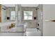 Bathroom featuring a marble vanity, bathtub, and neutral tiled shower with matte black fixtures at 390 Windermere Dr, Lakeland, FL 33809