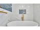 Modern bathroom features marble tile, a soaking tub, and stylish gold fixtures at 390 Windermere Dr, Lakeland, FL 33809