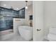 Luxurious bathroom with a freestanding tub, custom tilework, gold fixtures, and a separate walk-in shower at 390 Windermere Dr, Lakeland, FL 33809