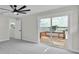 Light-filled bedroom with ceiling fan, an outdoor deck and water view through a large sliding glass door at 390 Windermere Dr, Lakeland, FL 33809