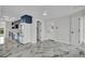 Bright dining area with bold blue kitchen cabinets, modern appliances, and white marbled floors at 390 Windermere Dr, Lakeland, FL 33809