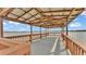 Covered wooden dock with ceiling fan offers serene waterfront views at 390 Windermere Dr, Lakeland, FL 33809