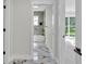 Hallway with marble floors leading to a bathroom and bedroom with a sliding glass door at 390 Windermere Dr, Lakeland, FL 33809