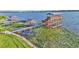 Scenic lake view featuring a multi-level private dock with multiple boat slips, a sun deck, and water vegetation at 390 Windermere Dr, Lakeland, FL 33809