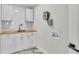 Well-equipped laundry room with wooden countertops, white cabinets, subway tile backsplash, and modern fixtures at 390 Windermere Dr, Lakeland, FL 33809