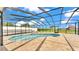 Outdoor screened-in pool with blue water, stone flooring and room for entertaining guests at 390 Windermere Dr, Lakeland, FL 33809