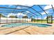 Screened-in pool and spa area with travertine tile surround at 390 Windermere Dr, Lakeland, FL 33809
