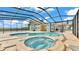 A luxurious screened-in pool area features a jacuzzi and ample space for relaxation and entertainment at 390 Windermere Dr, Lakeland, FL 33809