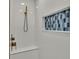 Modern shower with white tile, blue accent wall, and sleek bronze fixtures at 390 Windermere Dr, Lakeland, FL 33809